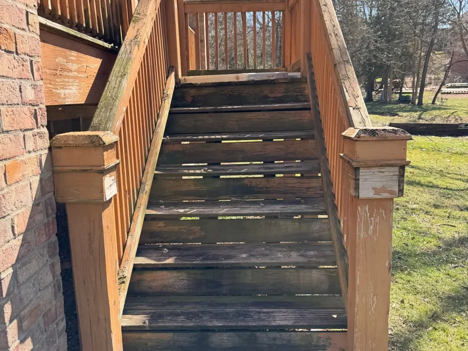 The original stairs and weathered wood railing.