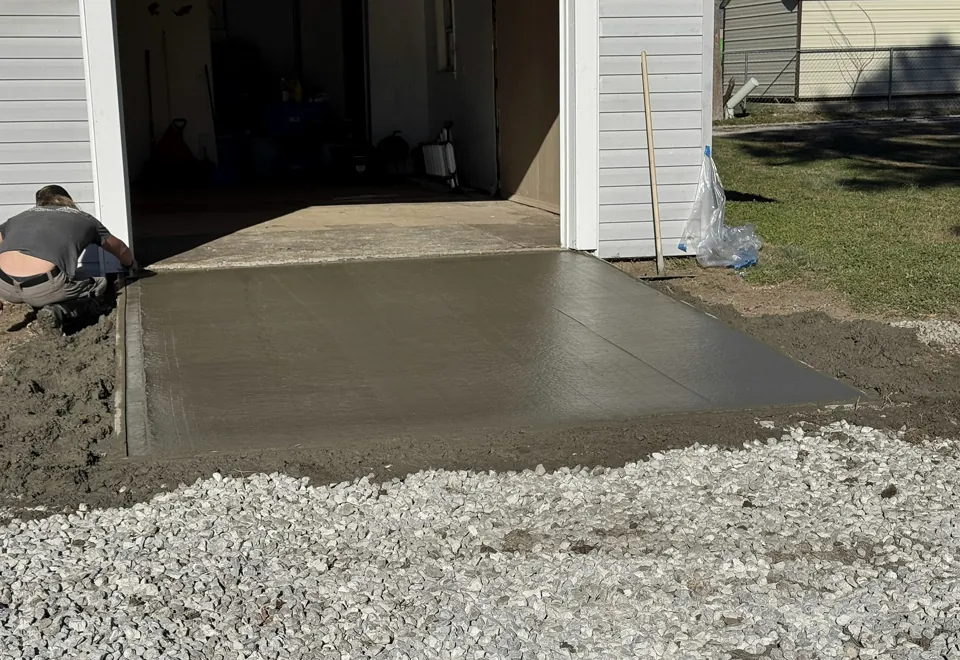 Finishing the fresh concrete apron outside the garage.
