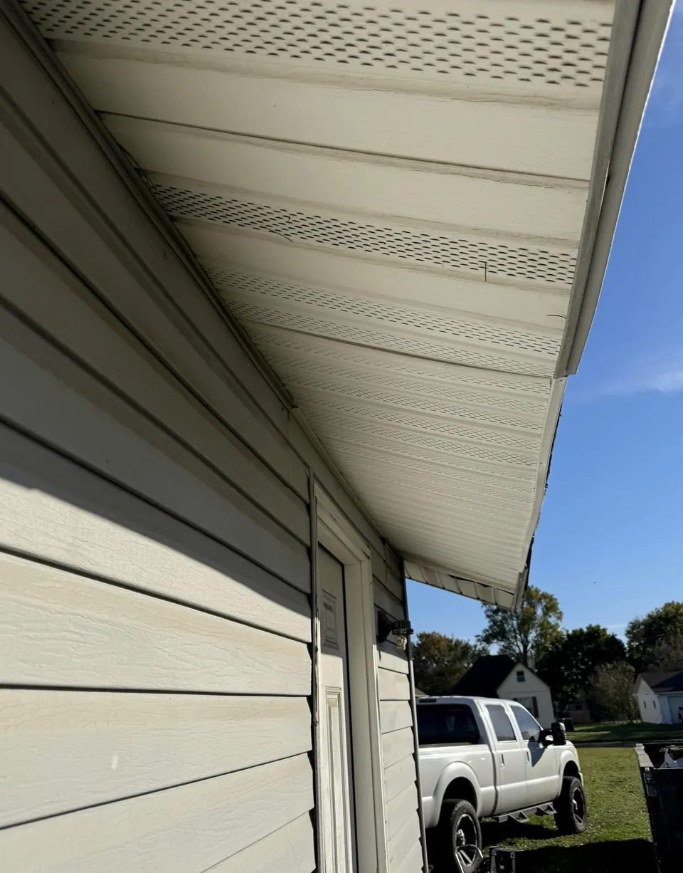 A close view of the siding, soffit, and roof edge.