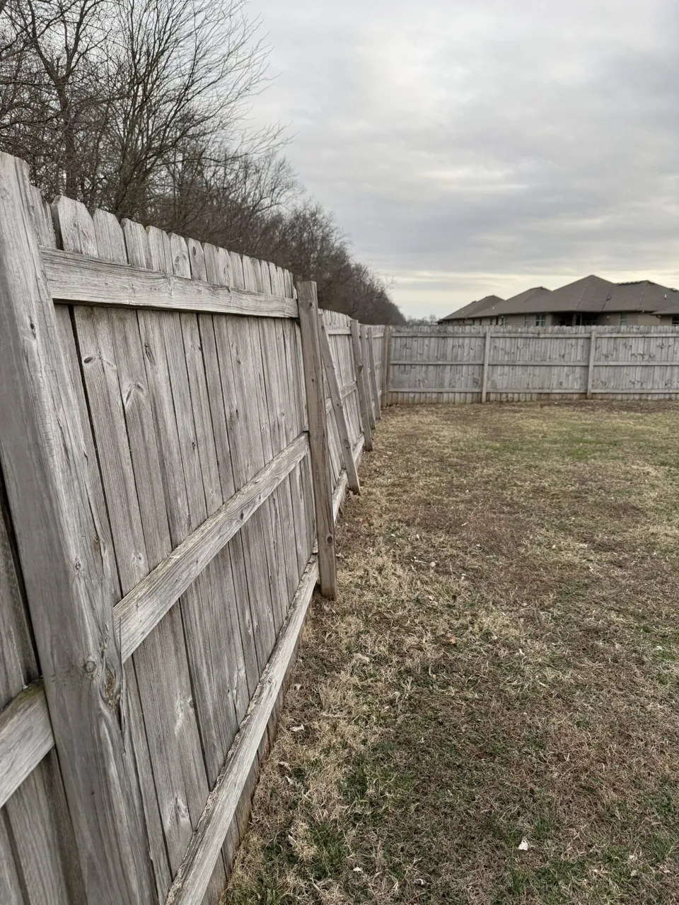 The leaning fence before repairs in March 2025.